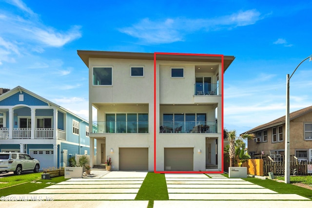 114 12th Ave S Unit 102, Jacksonville Beach, FL 32250 - view of front of home featuring concrete driveway, stucco siding, an attached garage, and a balcony