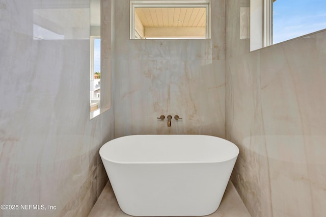 114 12th Ave S Unit 102, Jacksonville Beach, FL 32250 - full bathroom with tile walls and a freestanding bath