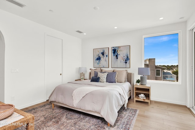 114 12th Ave S Unit 102, Jacksonville Beach, FL 32250 - bedroom with arched walkways, light wood-style floors, and recessed lighting