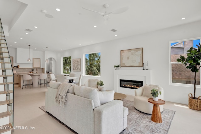 114 12th Ave S Unit 102, Jacksonville Beach, FL 32250 - living room with ceiling fan, recessed lighting, a glass covered fireplace, stairway, and arched walkways