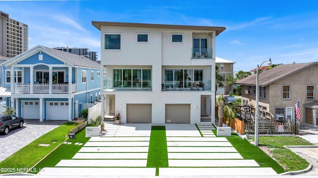 114 12th Ave S Unit 102, Jacksonville Beach, FL 32250 - view of front of house featuring driveway, an attached garage, stucco siding, and a balcony