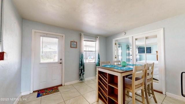 dining space with light tile patterned flooring and baseboards