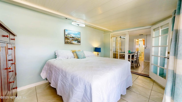 bedroom featuring light tile patterned floors, french doors, and baseboards