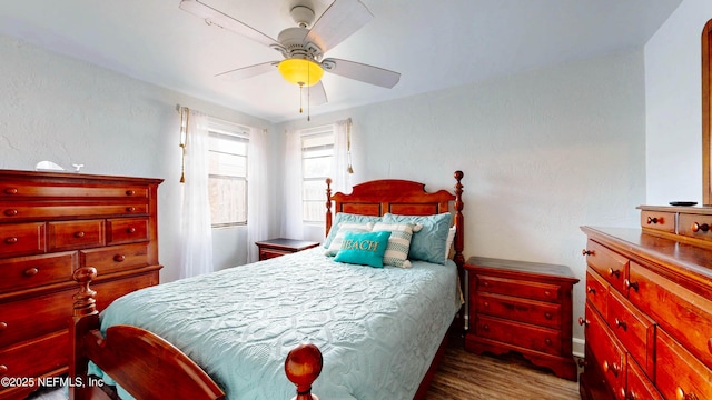 bedroom with wood finished floors, a ceiling fan, and baseboards