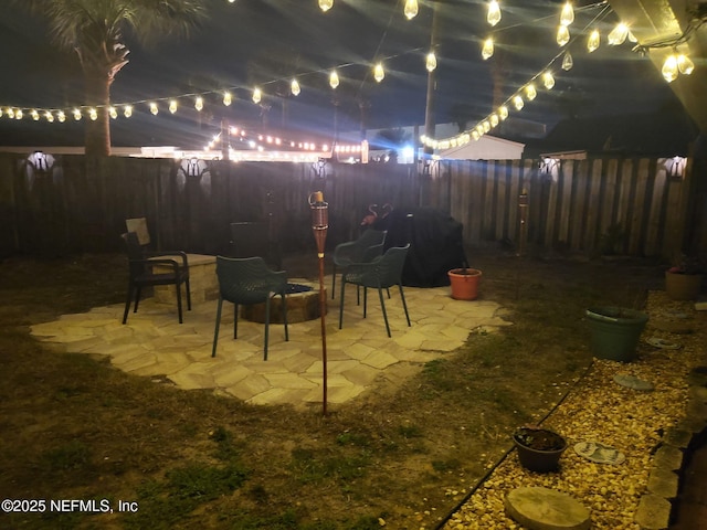 yard at twilight featuring a fenced backyard and a patio area