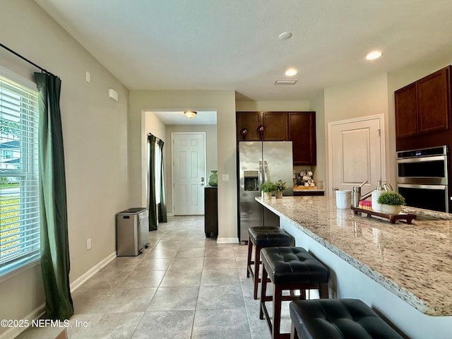 195 Torres Trce, Saint Augustine, FL 32095 - kitchen featuring stainless steel appliances, a breakfast bar, baseboards, dark brown cabinetry, and recessed lighting