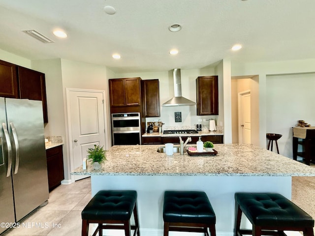 195 Torres Trce, Saint Augustine, FL 32095 - kitchen featuring stainless steel appliances, wall chimney exhaust hood, a sink, a kitchen breakfast bar, and dark brown cabinets