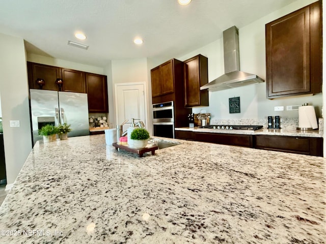195 Torres Trce, Saint Augustine, FL 32095 - kitchen with wall chimney range hood, appliances with stainless steel finishes, light stone counters, dark brown cabinets, and recessed lighting