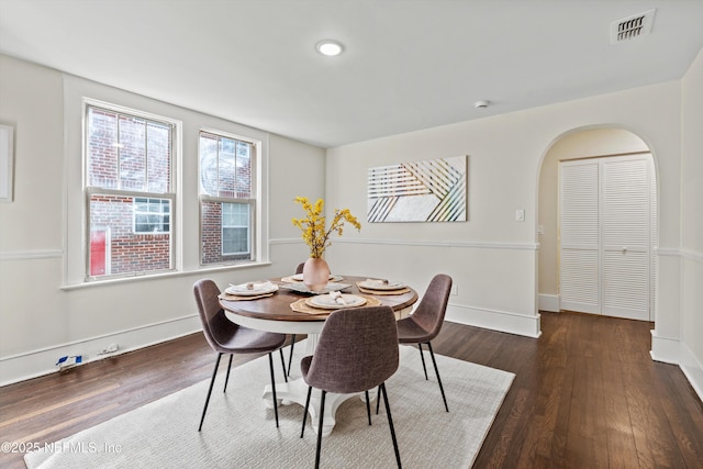3577 Valencia Rd, Jacksonville, FL 32205 - dining room with dark wood-style flooring, baseboards, and arched walkways