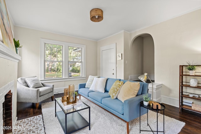 3577 Valencia Rd, Jacksonville, FL 32205 - living area featuring arched walkways, dark wood-style floors, ornamental molding, and baseboards