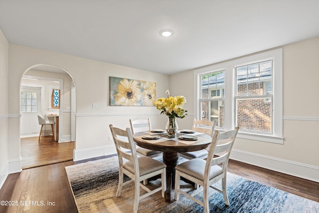 3577 Valencia Rd, Jacksonville, FL 32205 - dining area with arched walkways, wood finished floors, and baseboards
