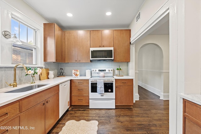 3577 Valencia Rd, Jacksonville, FL 32205 - kitchen featuring white appliances, a sink, light countertops, dark wood-style flooring, and tasteful backsplash