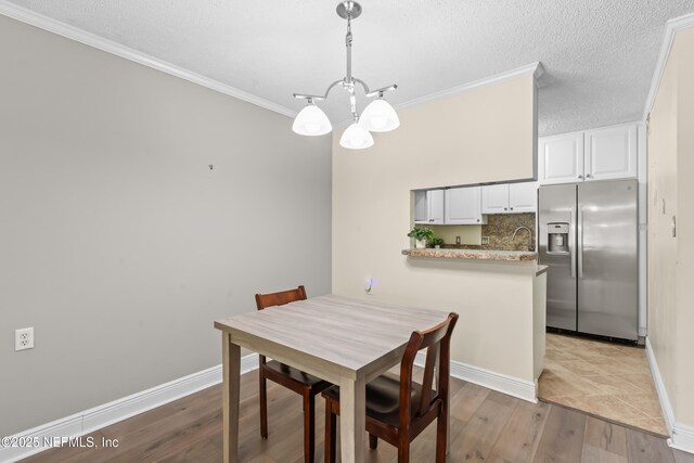 1071 Edgewood Ave S Unit 206, Jacksonville, FL 32205 - dining room featuring a chandelier, crown molding, wood finished floors, and a textured ceiling