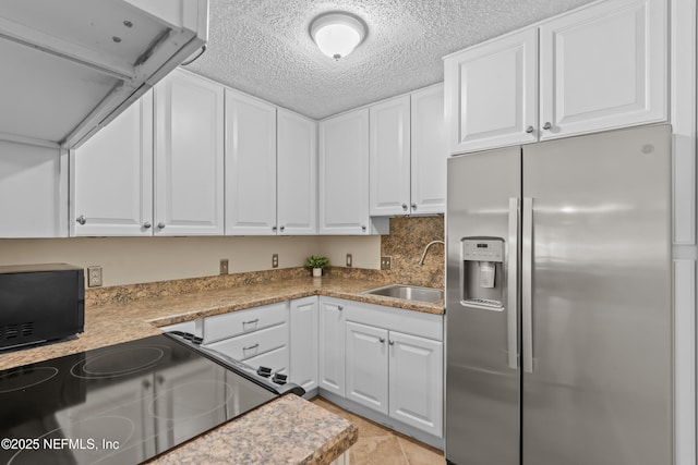 1071 Edgewood Ave S Unit 206, Jacksonville, FL 32205 - kitchen featuring stainless steel refrigerator with ice dispenser, electric range, white cabinetry, black microwave, and a textured ceiling
