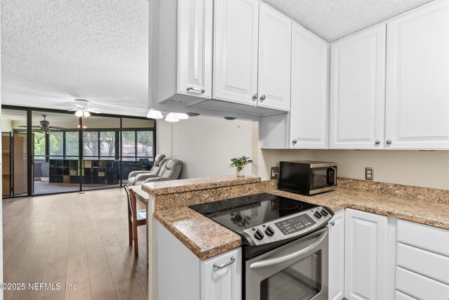 1071 Edgewood Ave S Unit 206, Jacksonville, FL 32205 - kitchen with appliances with stainless steel finishes, a textured ceiling, ceiling fan, white cabinetry, and open floor plan