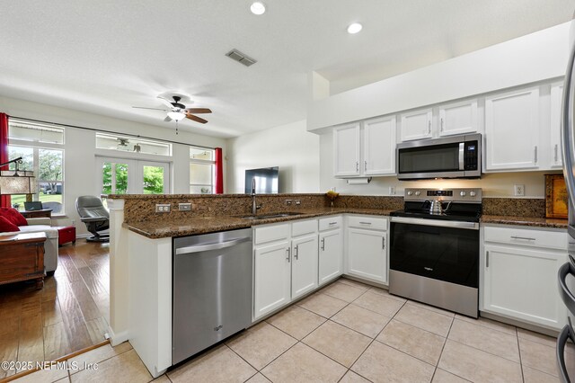 364 Maplewood Dr, Saint Johns, FL 32259 - kitchen featuring stainless steel appliances, a peninsula, ceiling fan, a sink, and white cabinets