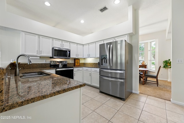 364 Maplewood Dr, Saint Johns, FL 32259 - kitchen with stainless steel appliances, a sink, dark stone counters, recessed lighting, and light carpet