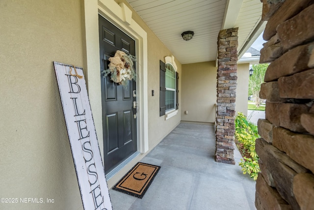 2443 Royal Pointe Dr, Green Cove Springs, FL 32043 - view of exterior entry with stucco siding and a porch