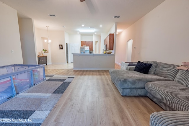 2443 Royal Pointe Dr, Green Cove Springs, FL 32043 - living room featuring light wood finished floors, arched walkways, a chandelier, recessed lighting, and baseboards