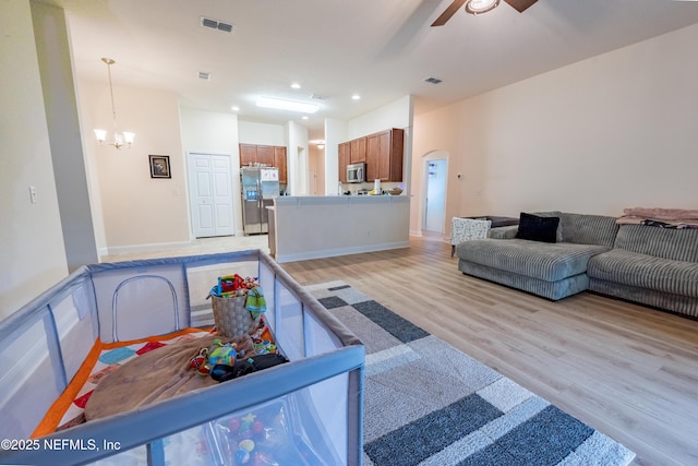 2443 Royal Pointe Dr, Green Cove Springs, FL 32043 - living area with light wood-type flooring, a ceiling fan, arched walkways, a chandelier, and recessed lighting