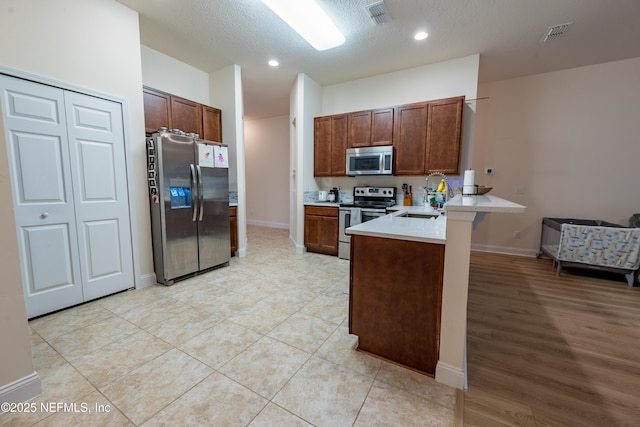 2443 Royal Pointe Dr, Green Cove Springs, FL 32043 - kitchen featuring stainless steel appliances, a peninsula, light countertops, baseboards, and recessed lighting