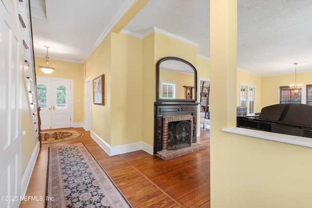 195 S Roscoe Blvd, Ponte Vedra Beach, FL 32082 - foyer featuring wood finished floors, french doors, ornamental molding, a chandelier, and a fireplace