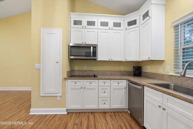 195 S Roscoe Blvd, Ponte Vedra Beach, FL 32082 - kitchen with appliances with stainless steel finishes, wood finished floors, a sink, white cabinets, and lofted ceiling