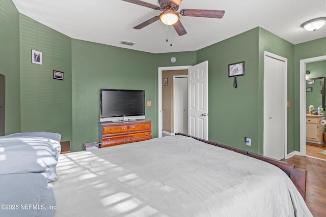 1655 The Greens Way Unit 2432, Jacksonville Beach, FL 32250 - bedroom with wood finished floors, baseboards, ensuite bathroom, and ceiling fan