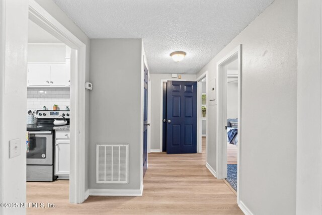 5164 Marlene Ave, Jacksonville, FL 32210 - hall with light wood finished floors, a textured ceiling, and baseboards