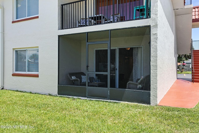 7175 A1A S Unit A108, Saint Augustine, FL 32080 - back of house with stucco siding, a lawn, and a balcony