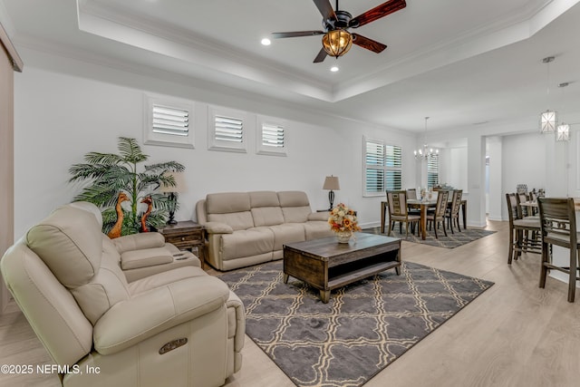 836 Margaritaville Ave, Daytona Beach, FL 32124 - living area with a tray ceiling, a chandelier, a ceiling fan, light wood-style flooring, and crown molding