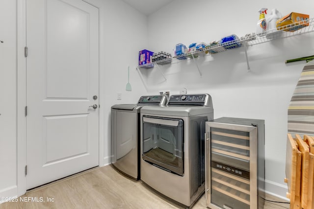 836 Margaritaville Ave, Daytona Beach, FL 32124 - laundry area with wine cooler, washing machine and dryer, light wood-style floors, and baseboards