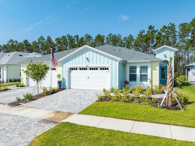 836 Margaritaville Ave, Daytona Beach, FL 32124 - ranch-style home with board and batten siding, an attached garage, decorative driveway, and a front lawn