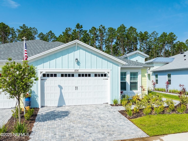 836 Margaritaville Ave, Daytona Beach, FL 32124 - ranch-style home featuring board and batten siding, a garage, roof with shingles, and decorative driveway
