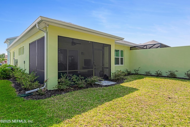 836 Margaritaville Ave, Daytona Beach, FL 32124 - rear view of property with a yard, stucco siding, a ceiling fan, and a sunroom