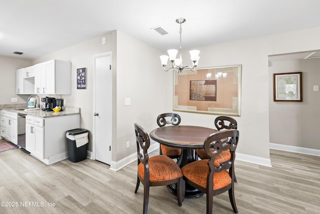 7315 Wonder Ln, Jacksonville, FL 32244 - dining area with a chandelier, light wood finished floors, and baseboards