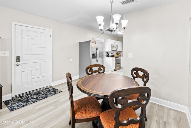 7315 Wonder Ln, Jacksonville, FL 32244 - dining room featuring light wood-style floors, a chandelier, and baseboards