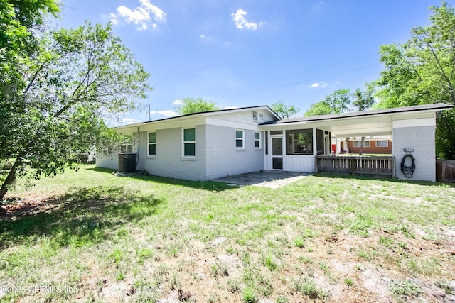 7315 Wonder Ln, Jacksonville, FL 32244 - rear view of house with brick siding, central AC unit, a sunroom, and a yard
