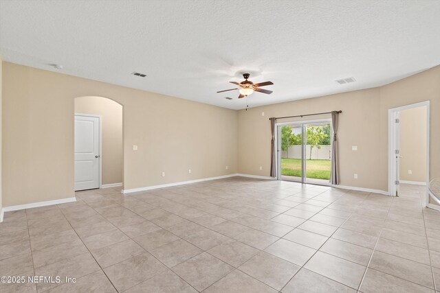 213 Haas Ave, Saint Augustine, FL 32095 - unfurnished room with a ceiling fan, arched walkways, light tile patterned floors, baseboards, and a textured ceiling