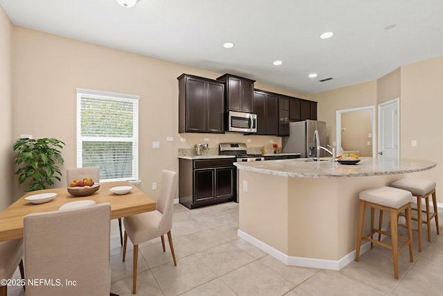 213 Haas Ave, Saint Augustine, FL 32095 - kitchen featuring stainless steel appliances, an island with sink, light tile patterned flooring, a kitchen breakfast bar, and a sink