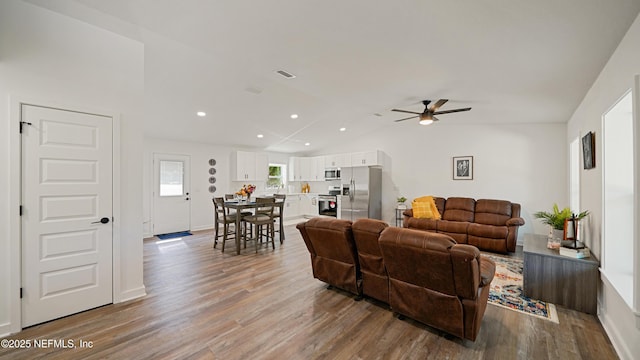 living area featuring a ceiling fan, wood finished floors, recessed lighting, vaulted ceiling, and baseboards