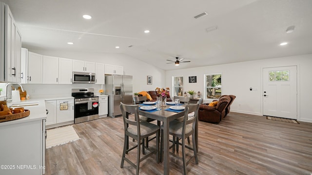 dining room featuring lofted ceiling, light wood-style flooring, ceiling fan, recessed lighting, and baseboards