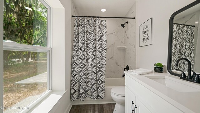 full bath with plenty of natural light, toilet, wood finished floors, shower / tub combo, and recessed lighting