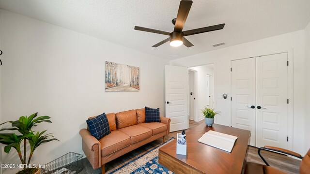 living room featuring ceiling fan, wood finished floors, and a desk