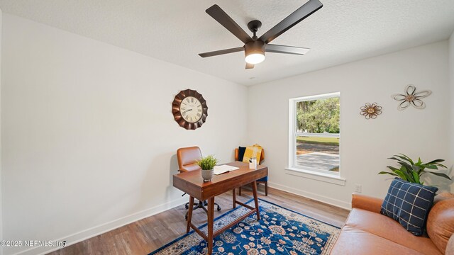 office space with wood finished floors, ceiling fan, baseboards, and a textured ceiling