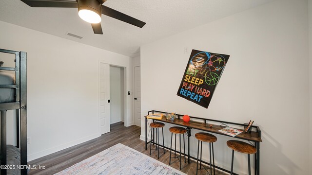 bedroom featuring wood finished floors, baseboards, and ceiling fan