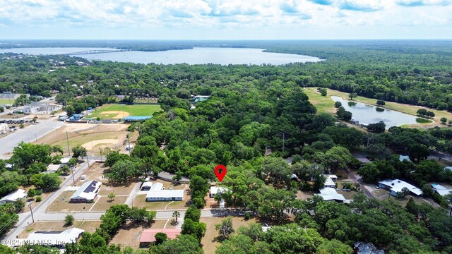 drone / aerial view of a nearby body of water and a forest