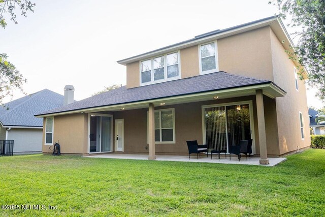 2543 Willow Creek Dr, Fleming Island, FL 32003 - back of property featuring a patio, stucco siding, a lawn, and a shingled roof