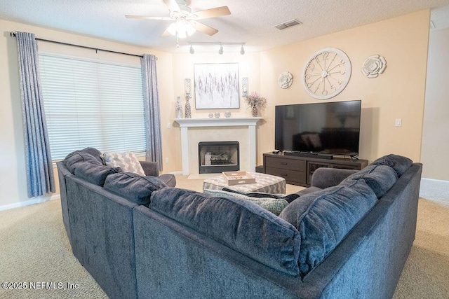 2543 Willow Creek Dr, Fleming Island, FL 32003 - carpeted living room with a fireplace with flush hearth, track lighting, ceiling fan, baseboards, and a textured ceiling