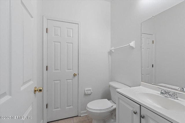 half bathroom featuring tile patterned floors, toilet, and vanity